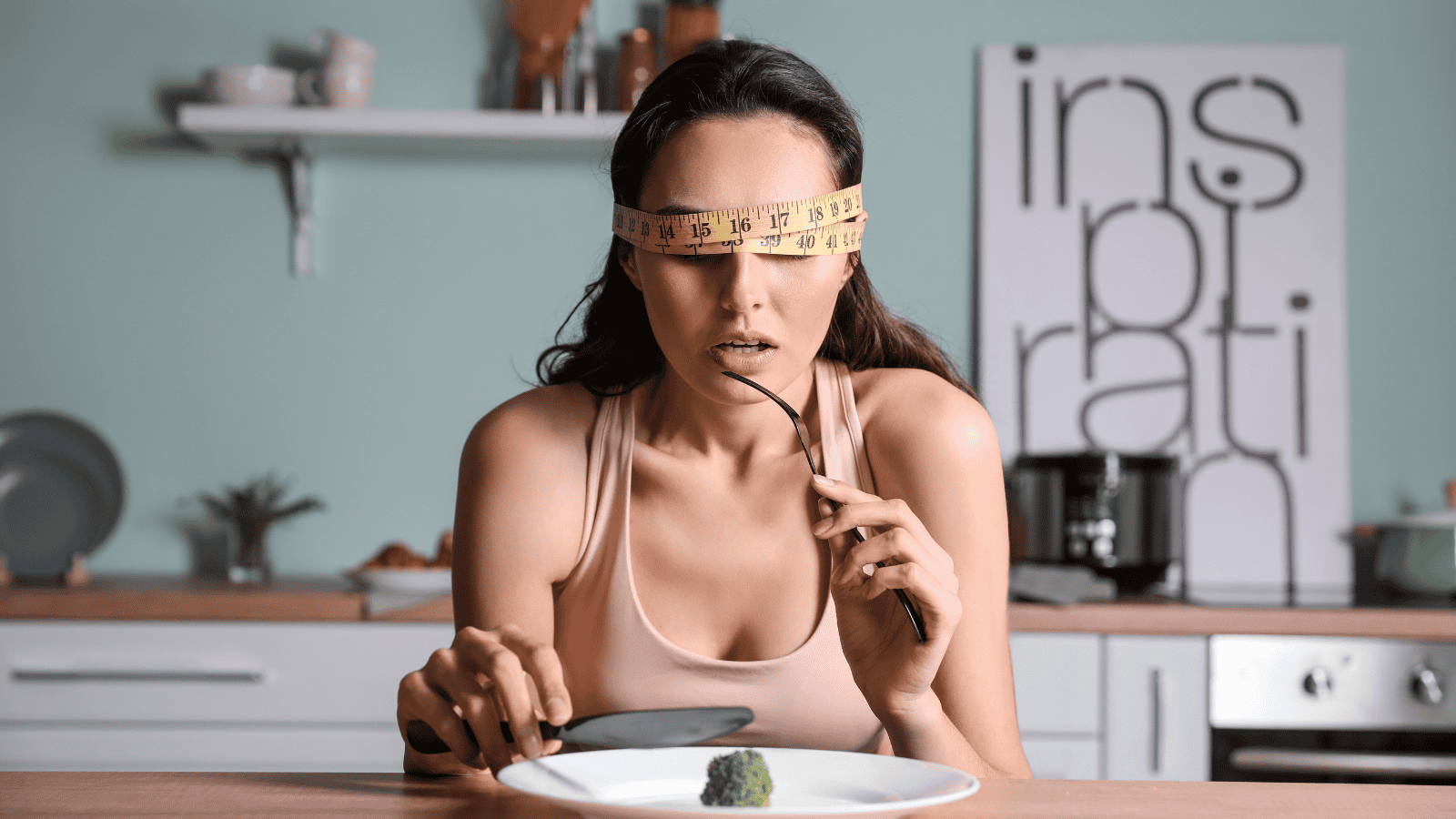 A young woman suffering from anorexia is eating broccoli